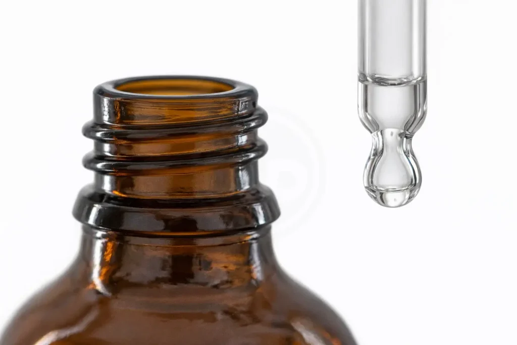 نمای نزدیک دهانه و قطره‌چکان بطری شیشه‌ای